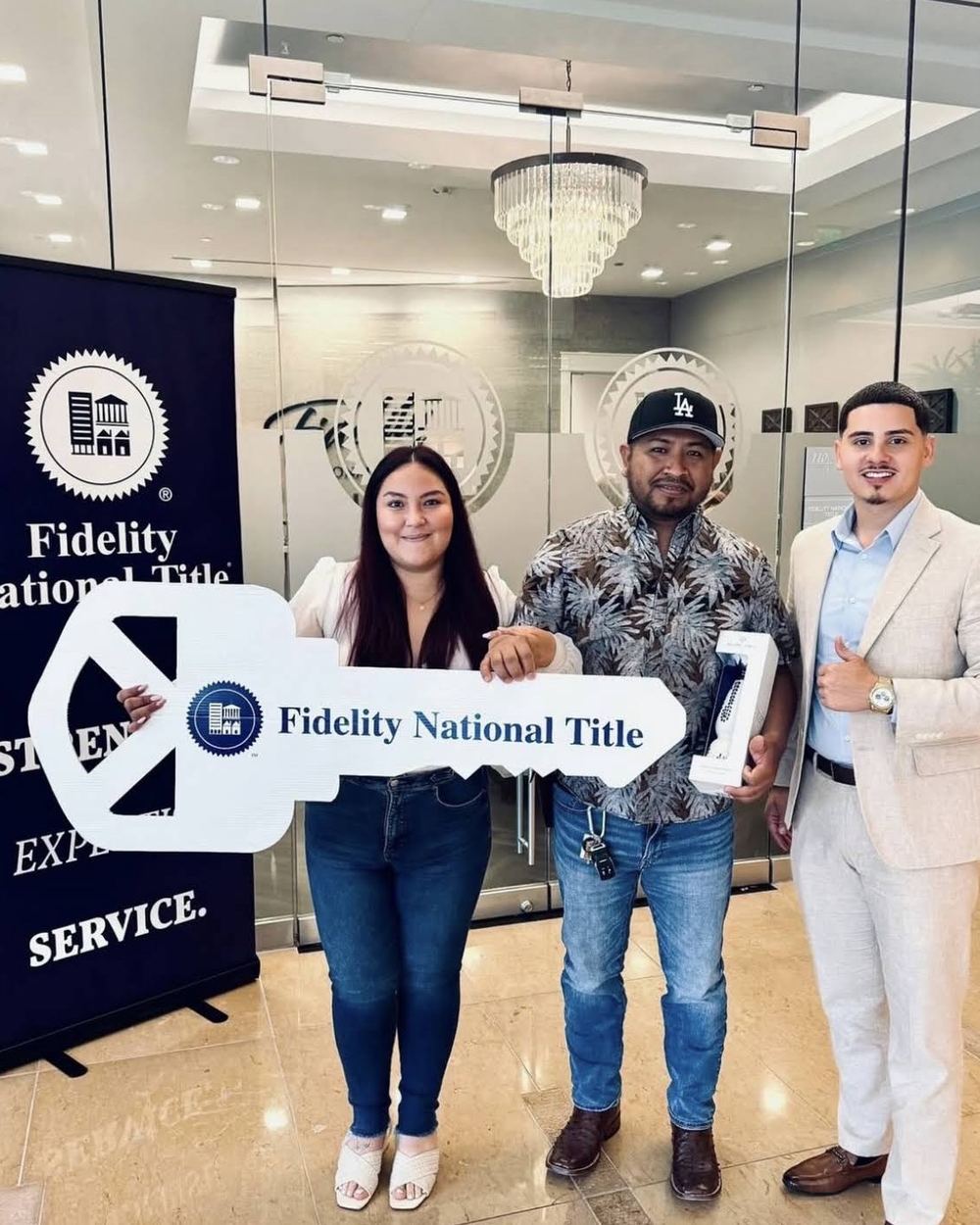 Buyers holding a Fidelity National Title key at the closing table