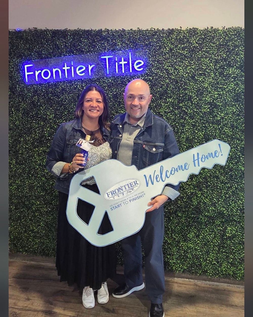 A couple holding a Frontier Title Welcome Home key