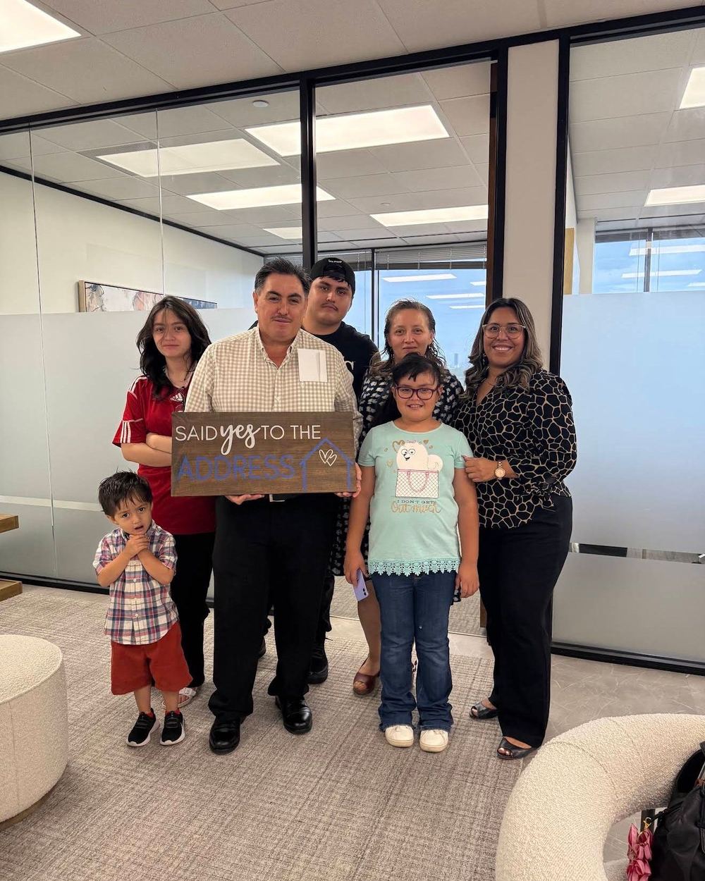 A multigenerational family holding a Said Yes To The Address sign