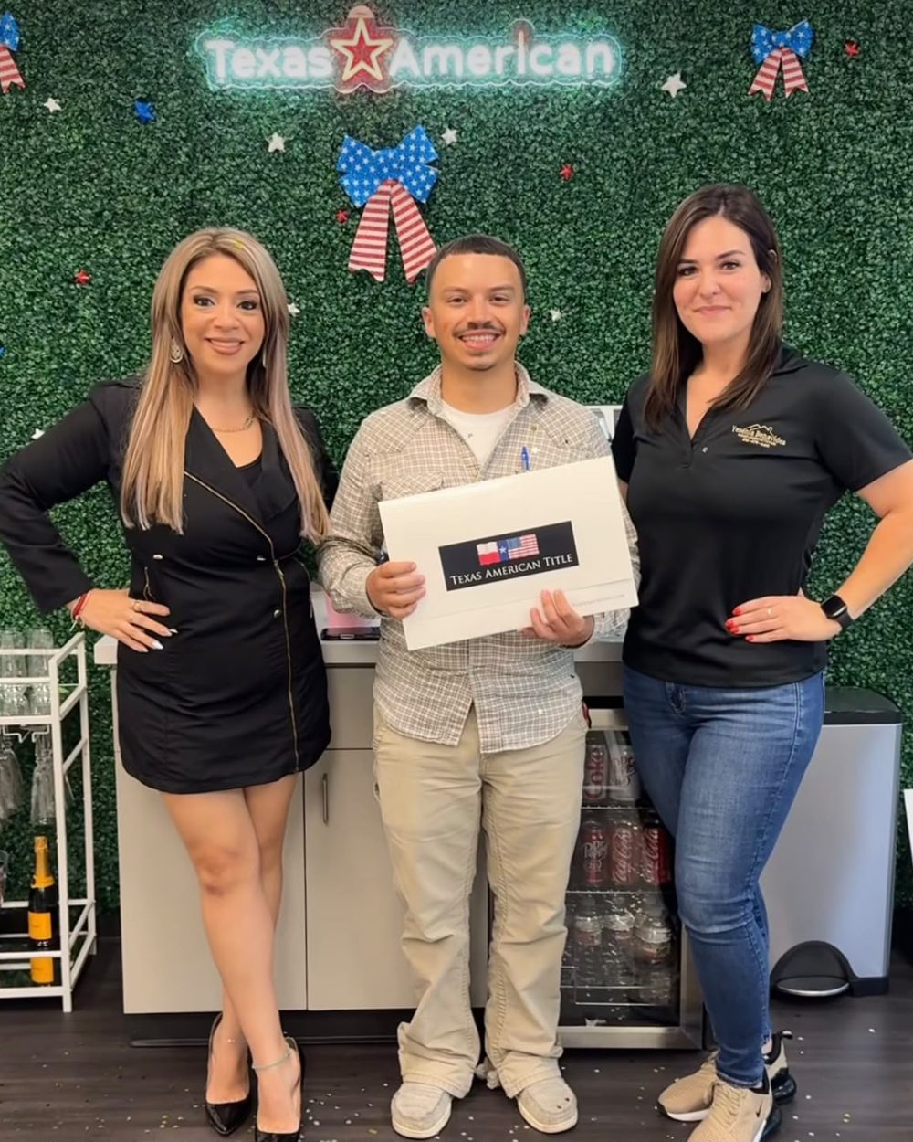 A buyer holding his closing folder with Yesenia and his agent