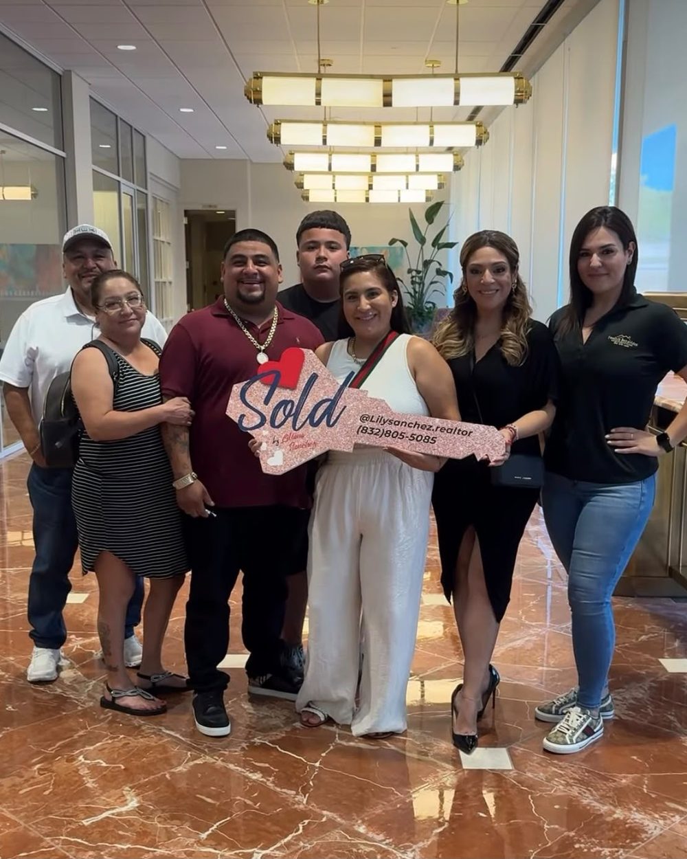 A family of seven celebrating closing day in the title company lobby