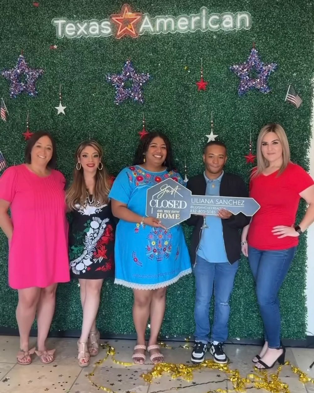 A buyer holding a Just Closed sign with Yesenia and the closing team