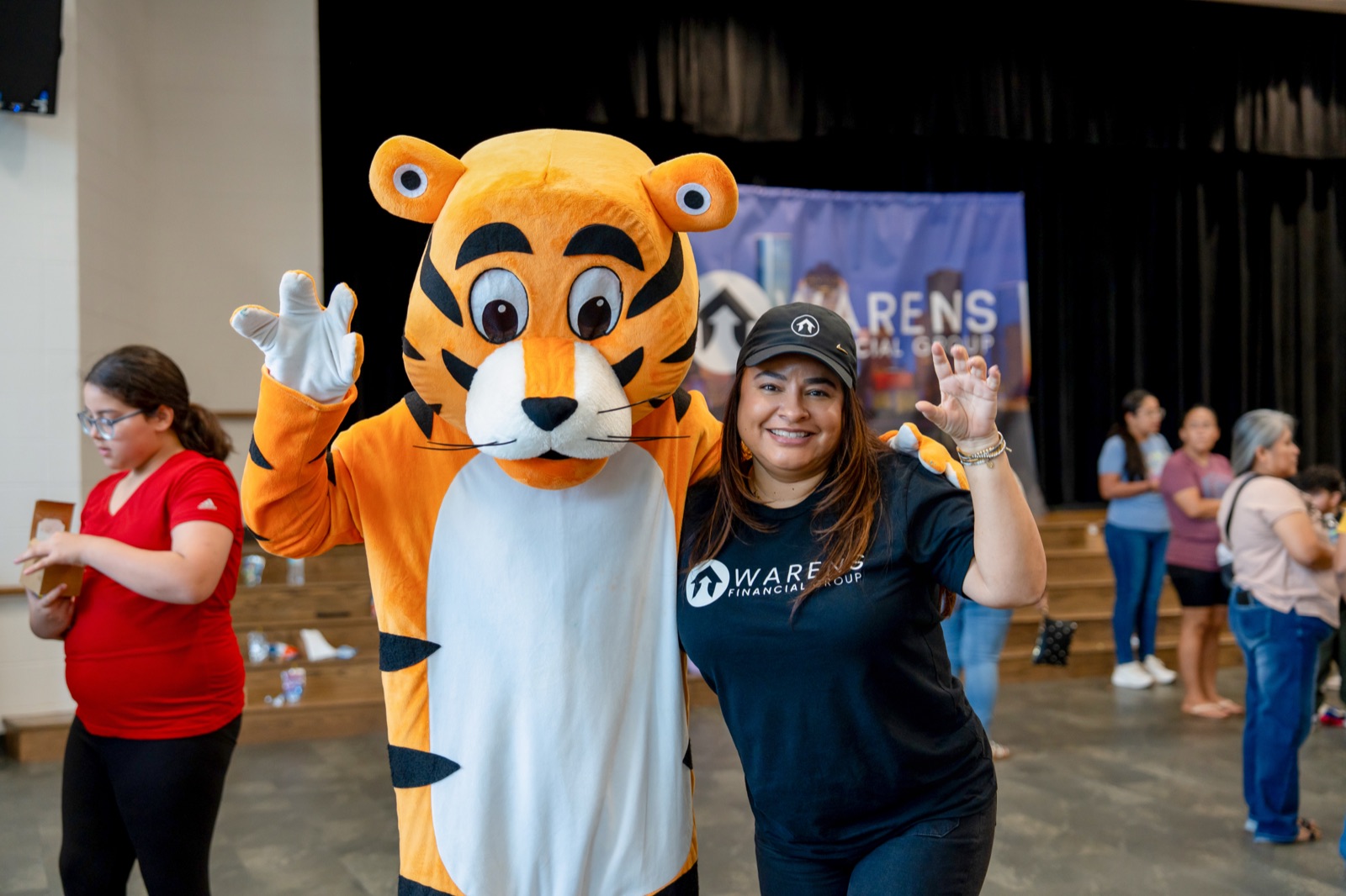 The Warens tiger mascot posing with a team member at the drive
