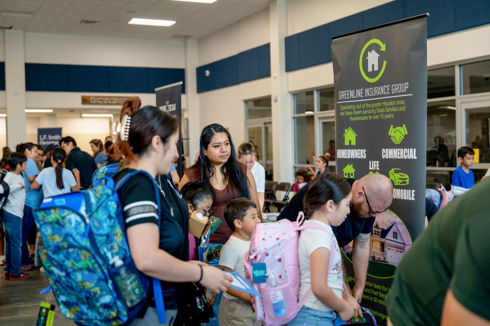Volunteers handing out backpacks to students