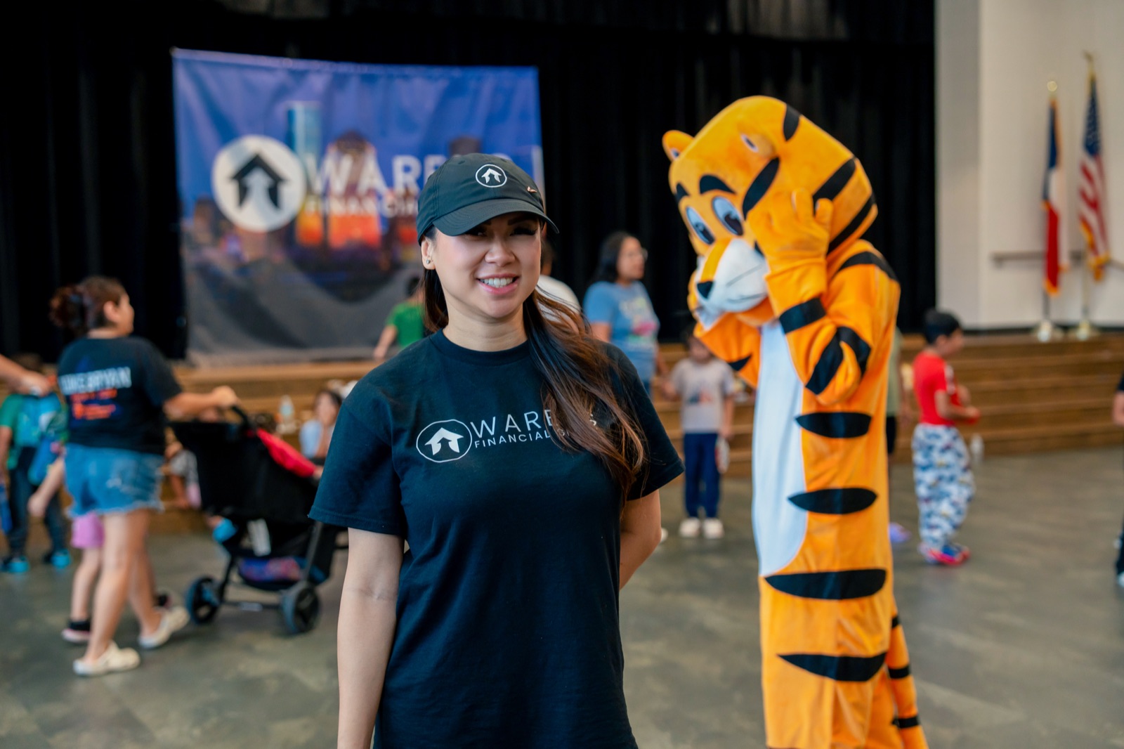 A team member smiling in front of the Warens backdrop