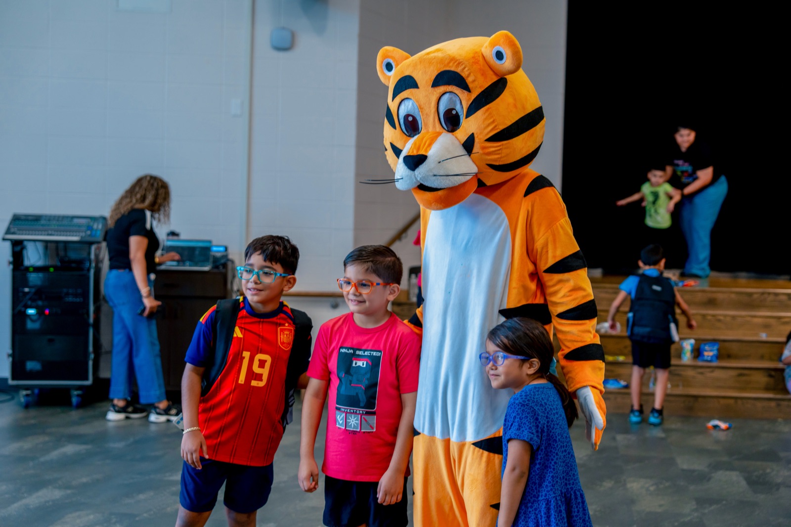 Three students posing with the tiger mascot