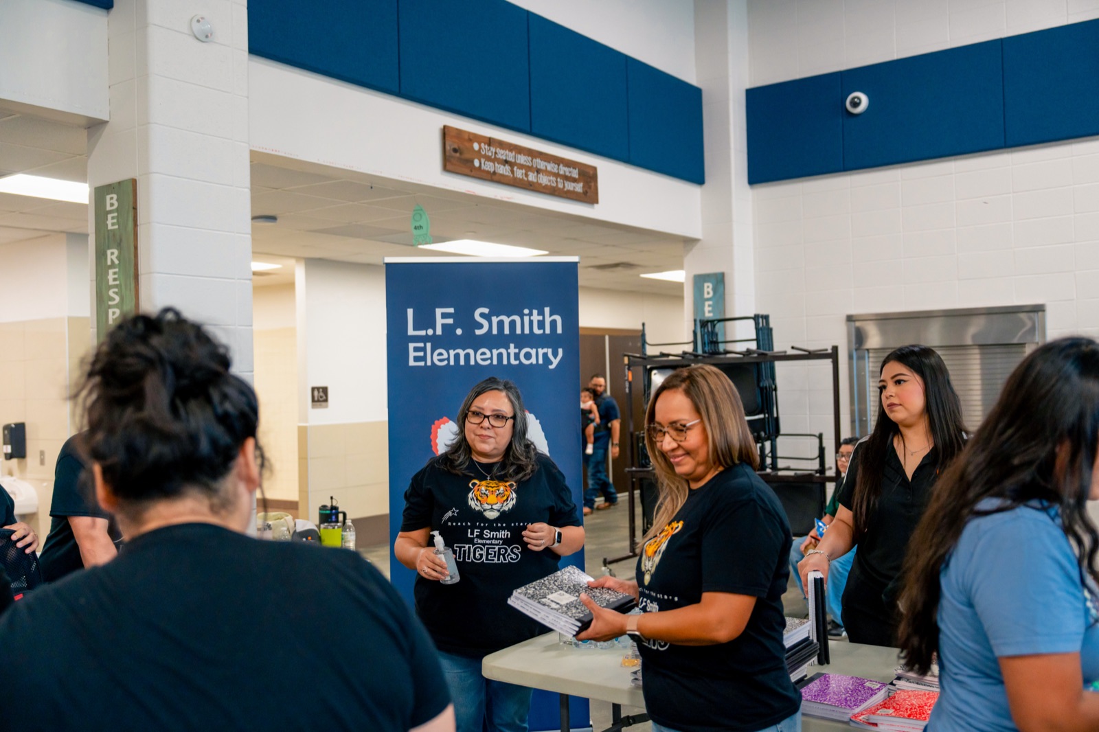 A volunteer handing out school supplies