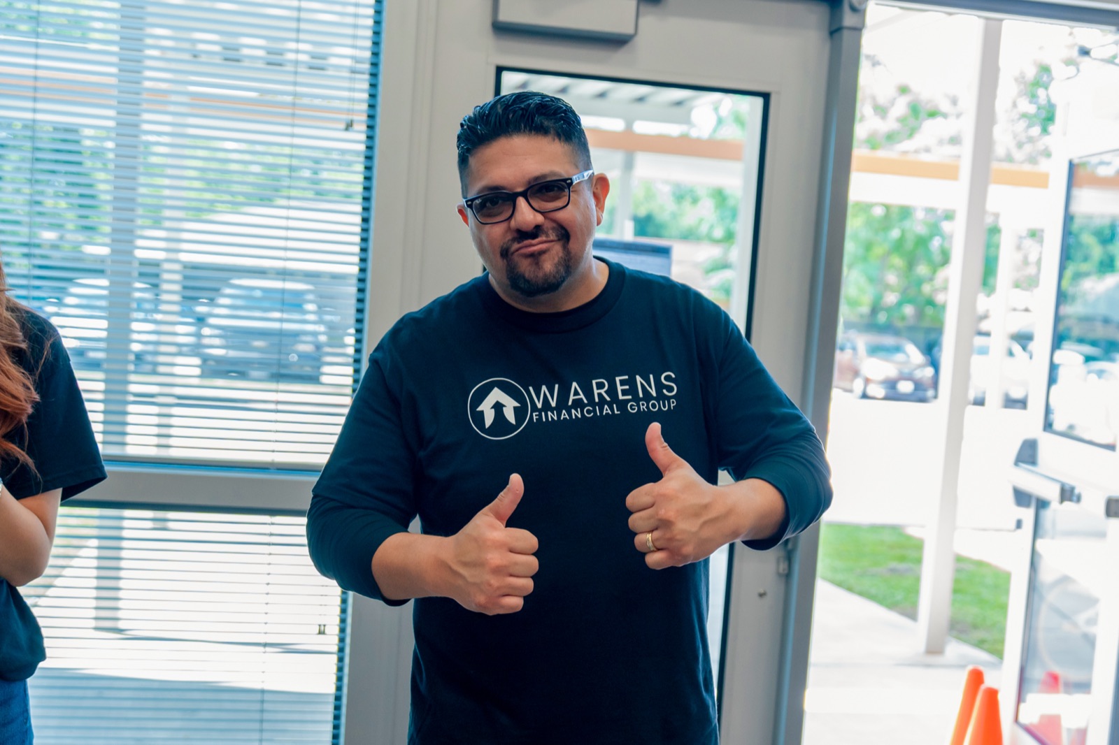 A Warens team member giving two thumbs up