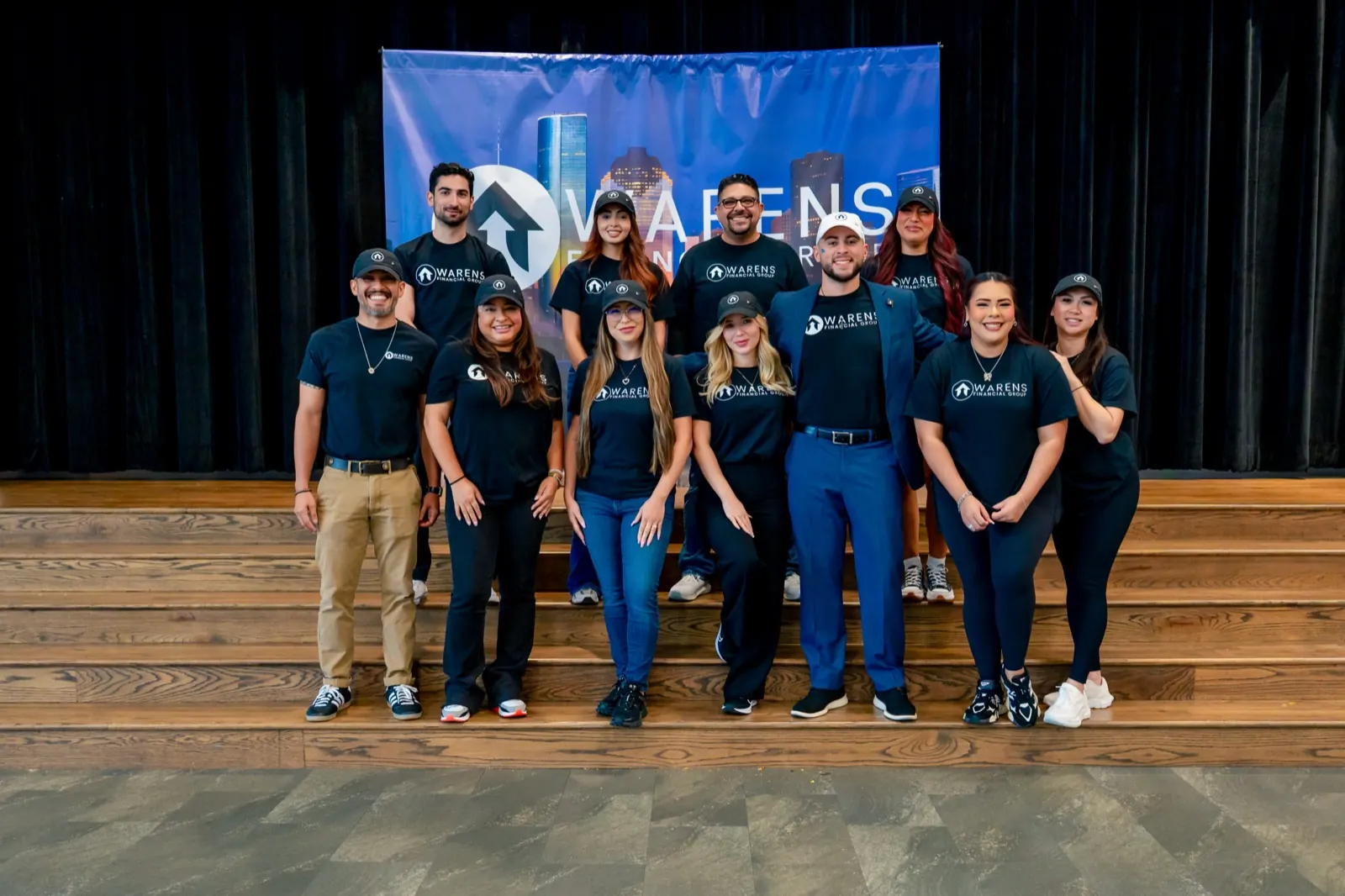 The Warens Financial Group team together on stage in matching team shirts