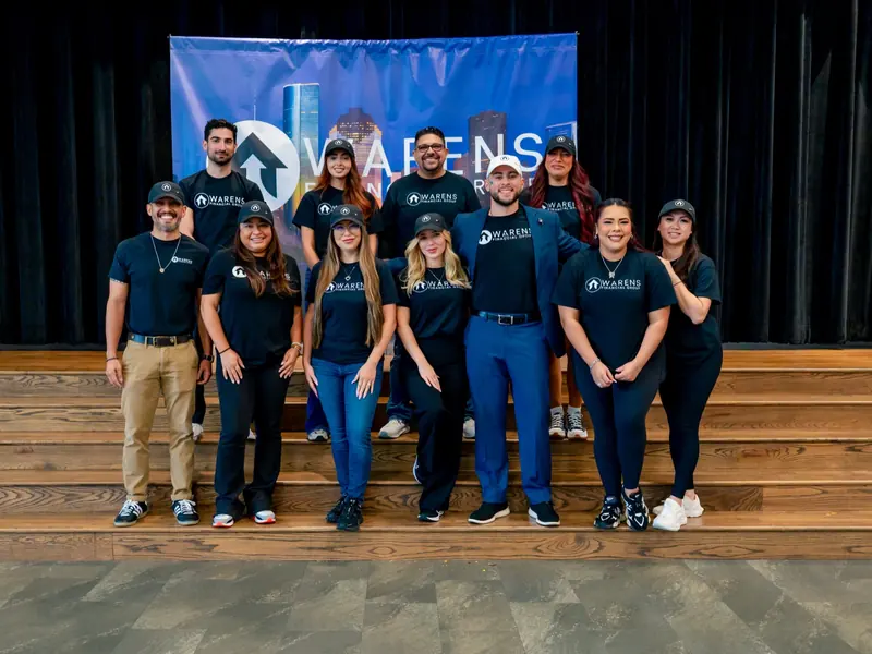 The Warens Financial Group team standing together on a stage